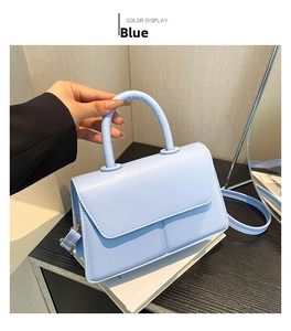 Detail of light blue PU leather handbag with smooth matte finish and top handle