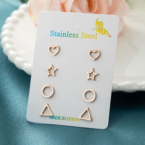 Detail of four rose gold stainless steel earrings in heart, star, and geometric shapes
