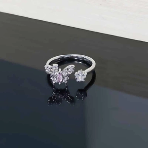 Macro detail of silver ring featuring pink heart butterfly and pavé zircon star charm