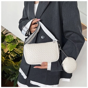 White woven shoulder bag with wide strap and round coin purse accessory detail