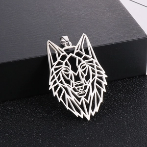 Gros plan du pendentif tête de loup géométrique en acier inoxydable argenté sur boîte noire