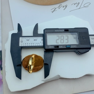 Detailed measurement of gold irregular geometric ring width showing 28.3mm on digital caliper