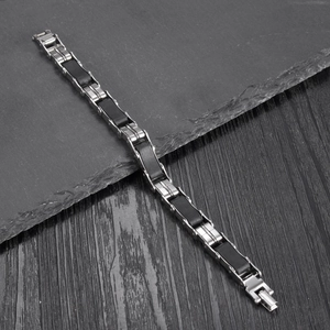 Classic men's stainless steel cross bracelet with black silicone links on a stone plate