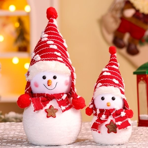Detail of plush Christmas snowmen with knitted hats and Welcome star signs in warm light