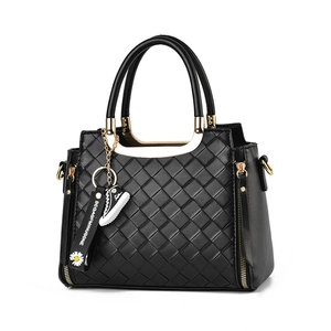 Black woven leather tote bag with gold hardware and stylish sneaker pendant charm
