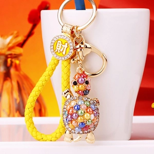 Detailed shot of a turtle keychain with colorful beads and a golden fortune charm