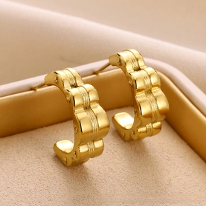 Close-up of gold-plated C-shaped earrings featuring a polished wavy geometric texture