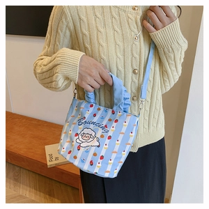 Detail of light blue striped bucket bag with cartoon sheep and ruffled handle strap