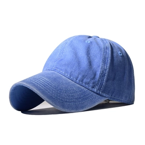 Close-up of blue washed cotton baseball cap showing detailed curved stitching and fabric texture