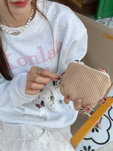 Petit sac de rangement beige à texture gaufrée pour rouge à lèvres et accessoires