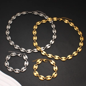 Detail view of coffee bean link chain necklaces and bracelets in gold and silver finishes