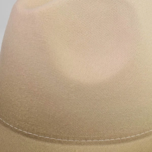 Detailed macro view of khaki wool felt fabric texture and white contrast stitching on the hat