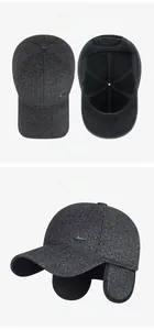Detail of dark grey wool baseball cap with earflaps and metal logo for winter
