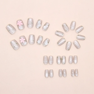 Close-up of floral press-on nails with cat eye pearls and 3D flower decorations