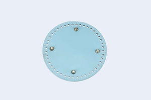 Detail of round light blue PU leather bag base with pre-punched holes and silver metal feet