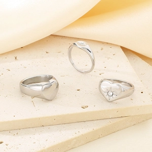 Detailed macro shot of silver heart and shield rings with star engraving on stone