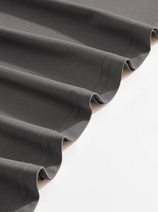 Detailed close-up of dark grey men's stretch shirt fabric with double-stitched hem finish