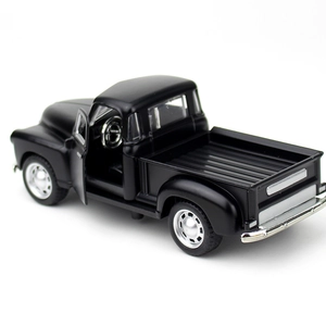 Macro shot of black vintage pickup model with open door showing detailed interior and steering wheel