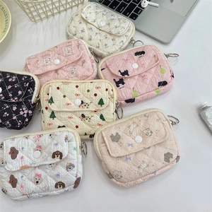 Flat lay of multiple floral quilted storage bags with cartoon prints and snap buttons