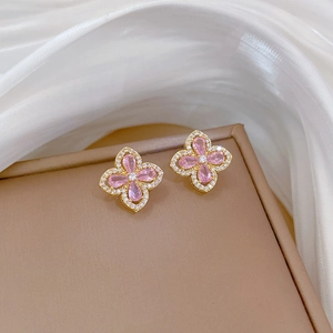 Macro view of floral stud earrings with pink drop-shaped gemstones and white diamonds
