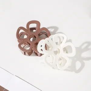 Detail of flower-shaped hair claws in brown and cream white with hollow petal design