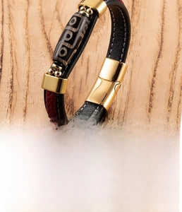Close-up of woven leather bracelet with magnetic steel clasp and ethnic bead detail
