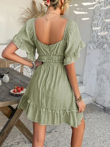 Rear view of light green ruffles mini dress with open back design and A-line silhouette