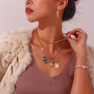 Close-up of multilayer 18K gold plated necklaces with snake, star and tarot pendants
