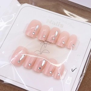 Faux ongles faits main rose nude avec strass argentés et finition brillante