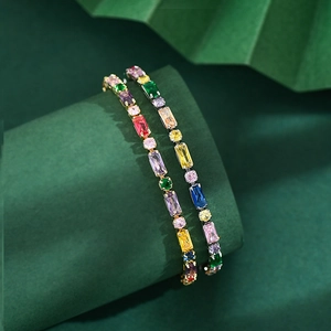 Close-up of vibrant multi-color zircon tennis bracelet on dark green texture