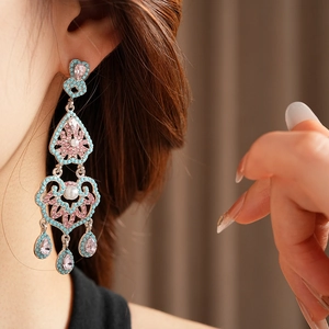 Gros plan de boucles d'oreilles vintage avec pierres bleues et roses sur un mannequin