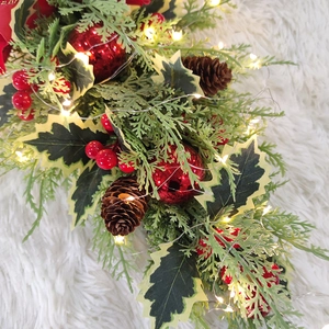 Detail of Christmas teardrop swag with LED lights, pine cones and red berries on white rug