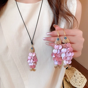 Detail of goldfish necklace with pink sequin scales and matching fish hook earrings set