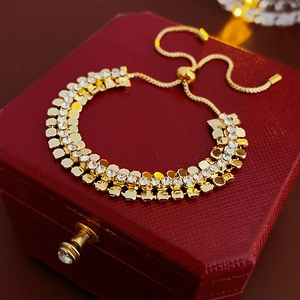 Détail macro d'un bracelet géométrique doré avec strass et fermoir à perles ajustable