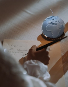 Artistic detail of 3D earth globe scented candle with detailed relief on gold tray