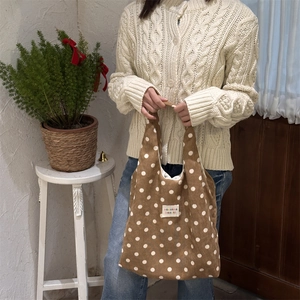 Close-up of brown polka dot canvas tote bag featuring a zakka beaute fabric label