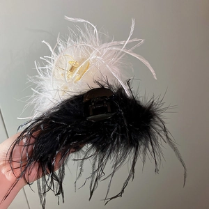 Detail of large fluffy ostrich feather hair claw clips in black and white colors