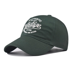 Detailed view of vintage white letter embroidery on dark green cotton baseball cap
