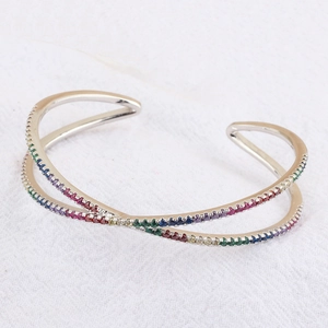 Detail showing high-polished silver crossover cuff bracelet with pavé rainbow zircons