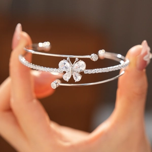 Detailaufnahme eines silbernen Schmetterlings-Armreifs mit funkelnden Zirkonia-Steinen