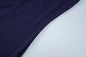 Detailed close-up showing the fine navy blue ribbed knit fabric texture of the dress