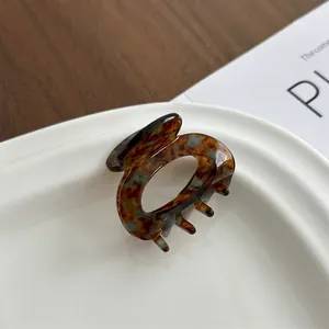 Elegant tortoiseshell acetate hair claw clip on a ceramic tray for a vintage style