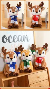 Close-up of plush Christmas reindeer dolls with sequins scarves in a cozy home setting
