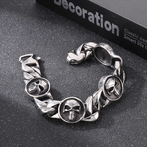 Detail of silver skull cuban link bracelet featuring a rugged vintage metal texture