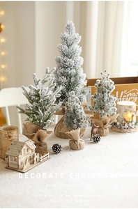 Miniature flocked Christmas trees with snow effect and rustic burlap base detail