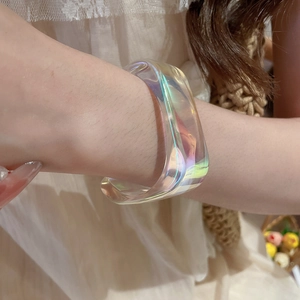 Macro detail of iridescent acrylic geometric bangle with translucent rainbow neon glow
