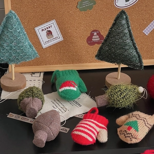 Close-up of knitted Christmas tree ornaments and gloves for festive DIY home decoration
