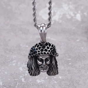 Macro detail of polished silver Jesus head pendant with rope chain and crown of thorns