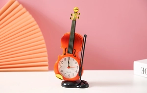 Dettaglio macro della sveglia al quarzo a forma di violino arancione con corde e arco