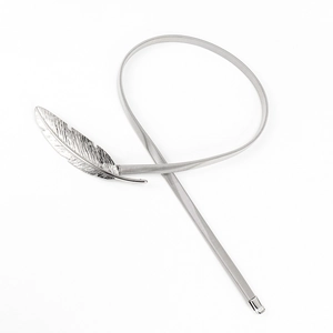 Detail shot of a silver spring metal waist belt with an intricate feather buckle design